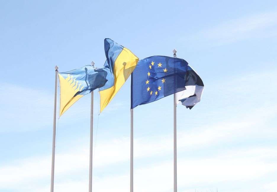 Élargissement UE : ce que ça change vraiment pour les Balkans European Union and Estonian flags wave under a clear blue sky, symbolizing unity and harmony.