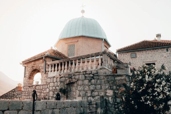 Que faire au Monténégro : mer, plages et nature sauvage Explore the historic Our Lady of the Rocks Church, a captivating landmark in Montenegro's scenic Bay of Kotor.
