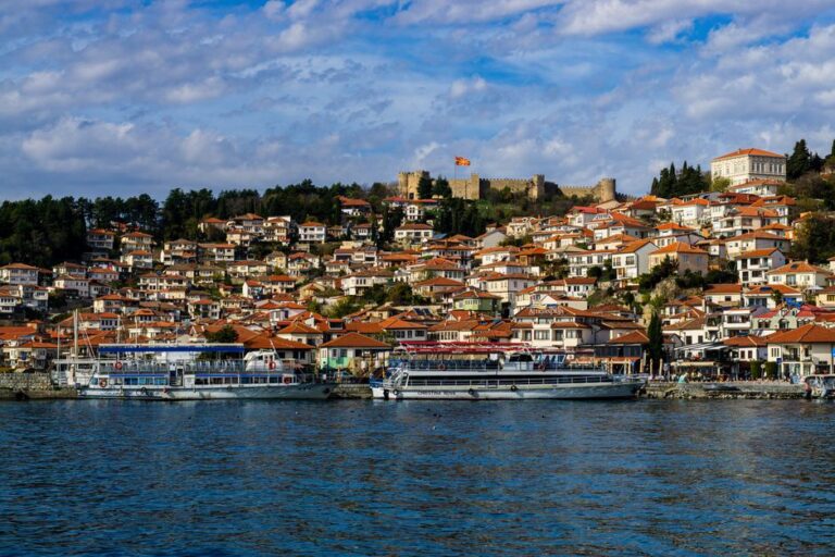Beautiful panoramic view of Ohrid's red-roofed houses and Lake Ohrid, with Samuil's Fortress in the background.