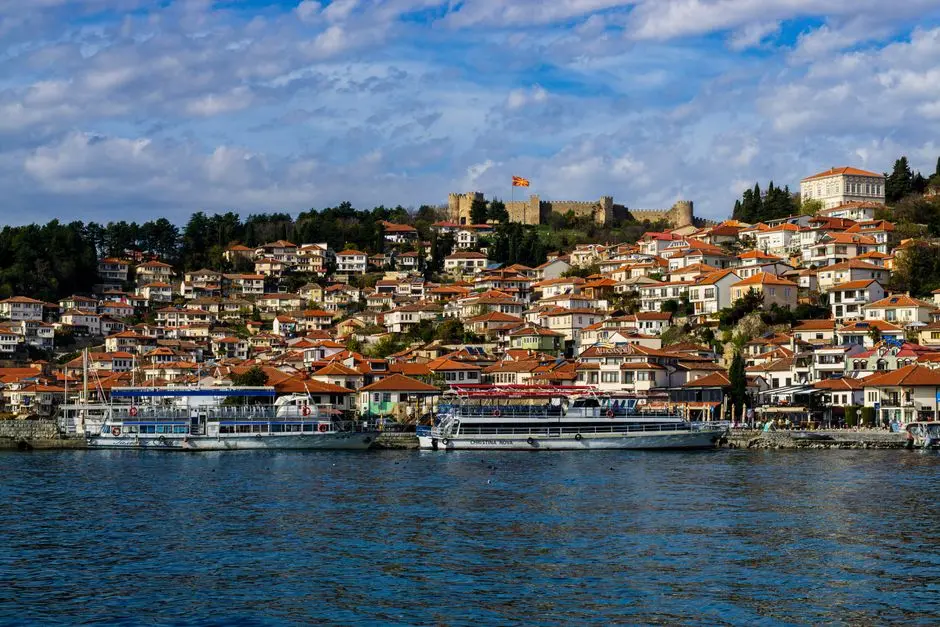 Beautiful panoramic view of Ohrid's red-roofed houses and Lake Ohrid, with Samuil's Fortress in the background.